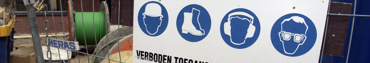 Sign on a fence around a construction site. With symbols for safety and no entry.